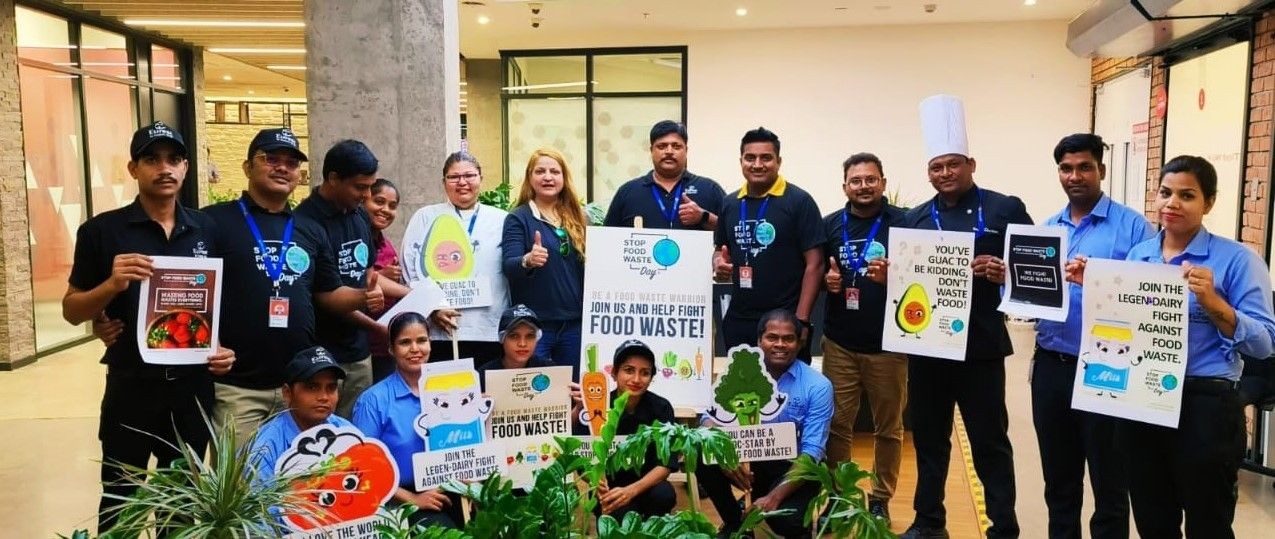 Group of chefs holding up Stop Food Waste Day posters