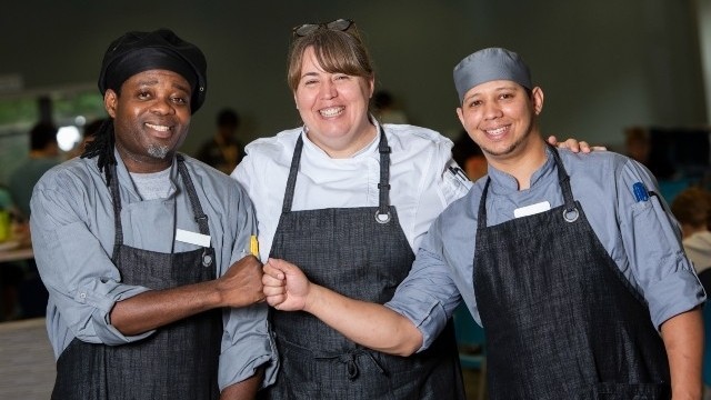 Three chefs fist pumping and smiling for the camera