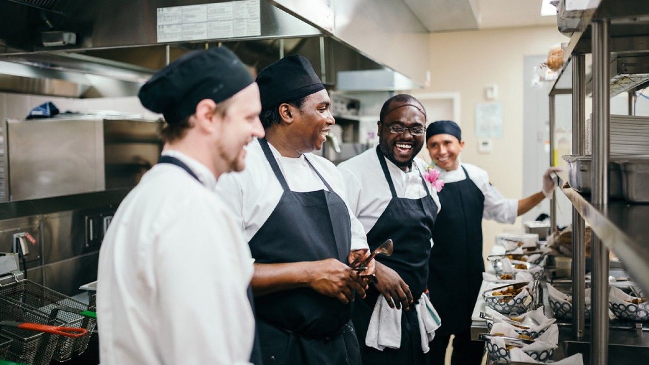 Meet our people teaser showing a chef dishing food to children